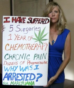 A cancer patient holds up a sign saying why was I arrested for marijuana
