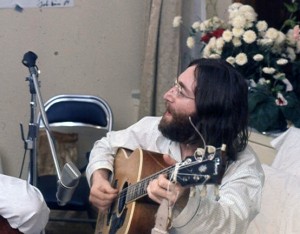John lennon with an acoustic guitar rehearsing "Give Peace a Chance"